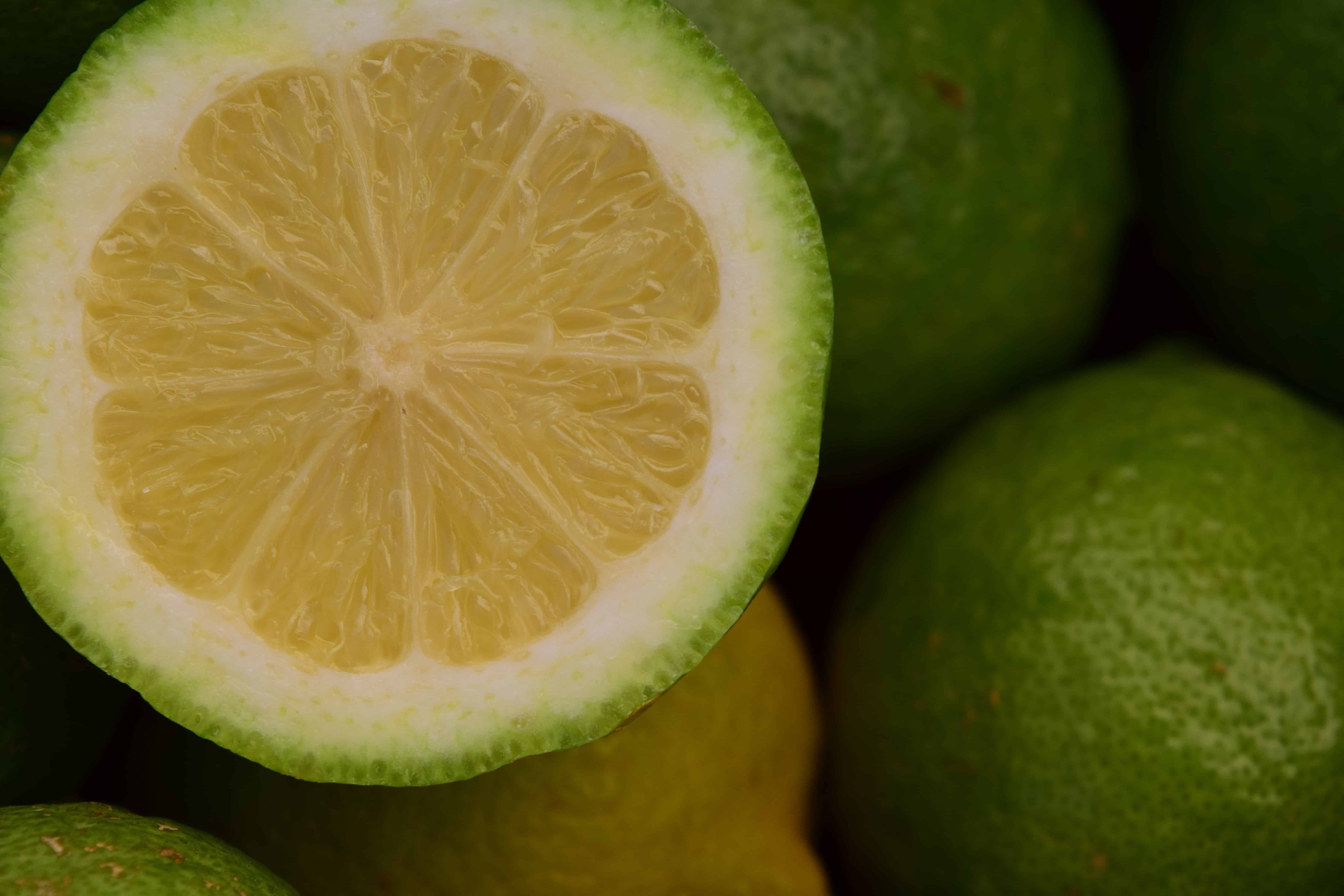 Зеленый лимон польза. Зеленый фрукт цитрус. Маленький зеленый цитрус. Померанец зеленый фрукт. Юдзу фрукт.